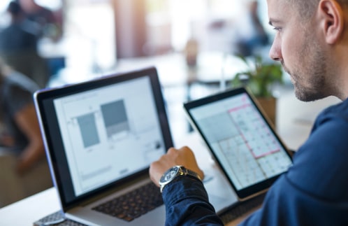 Business Man Looking Analyzing Projects His Laptop Computer Tablet 1 1 Min.jpg